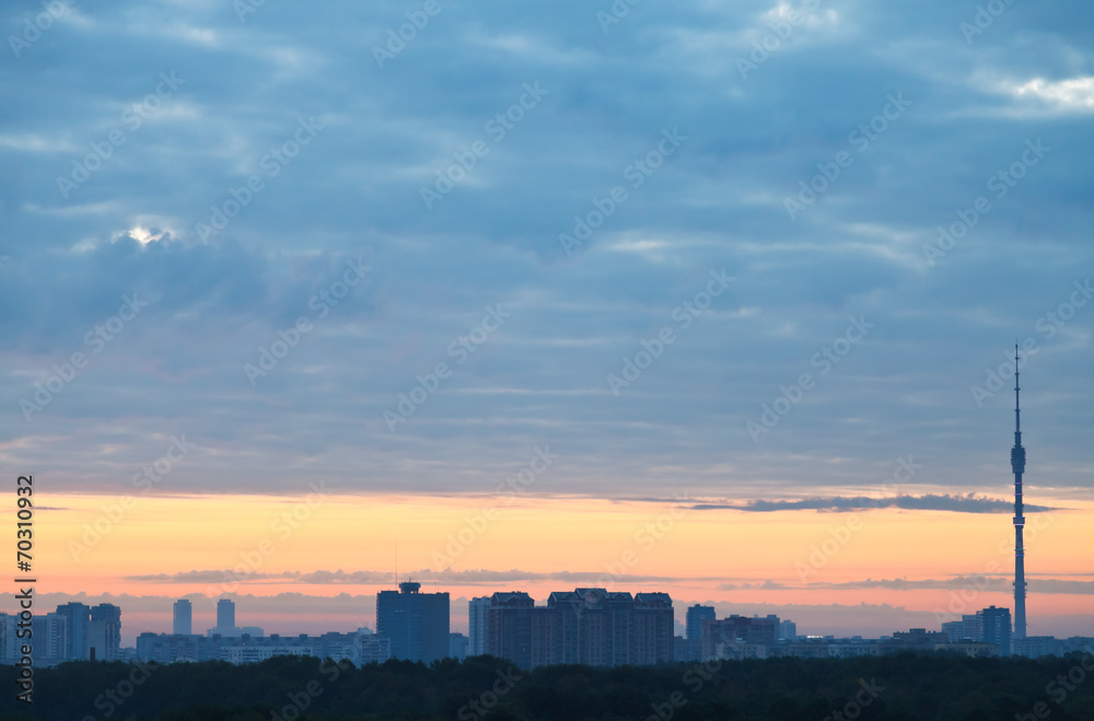 blue clouds and yellow sunrise sky over city