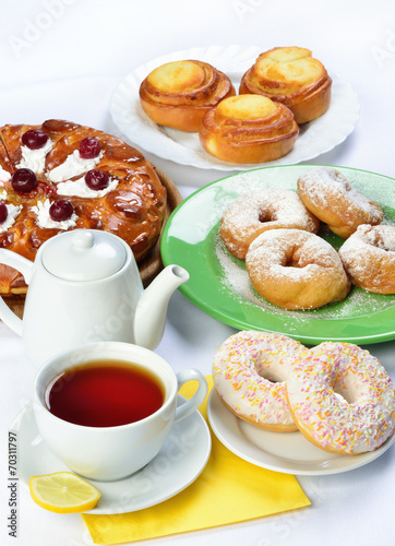 still life of setout table with baking pies, donuts, tee cup and