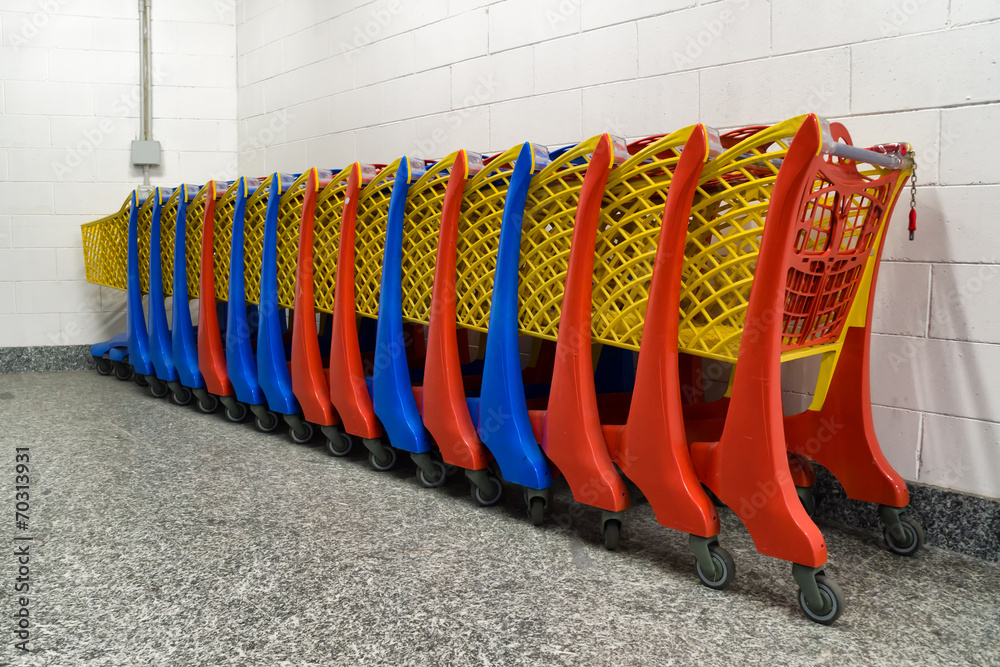row of colorful shopping trolley in supermarket