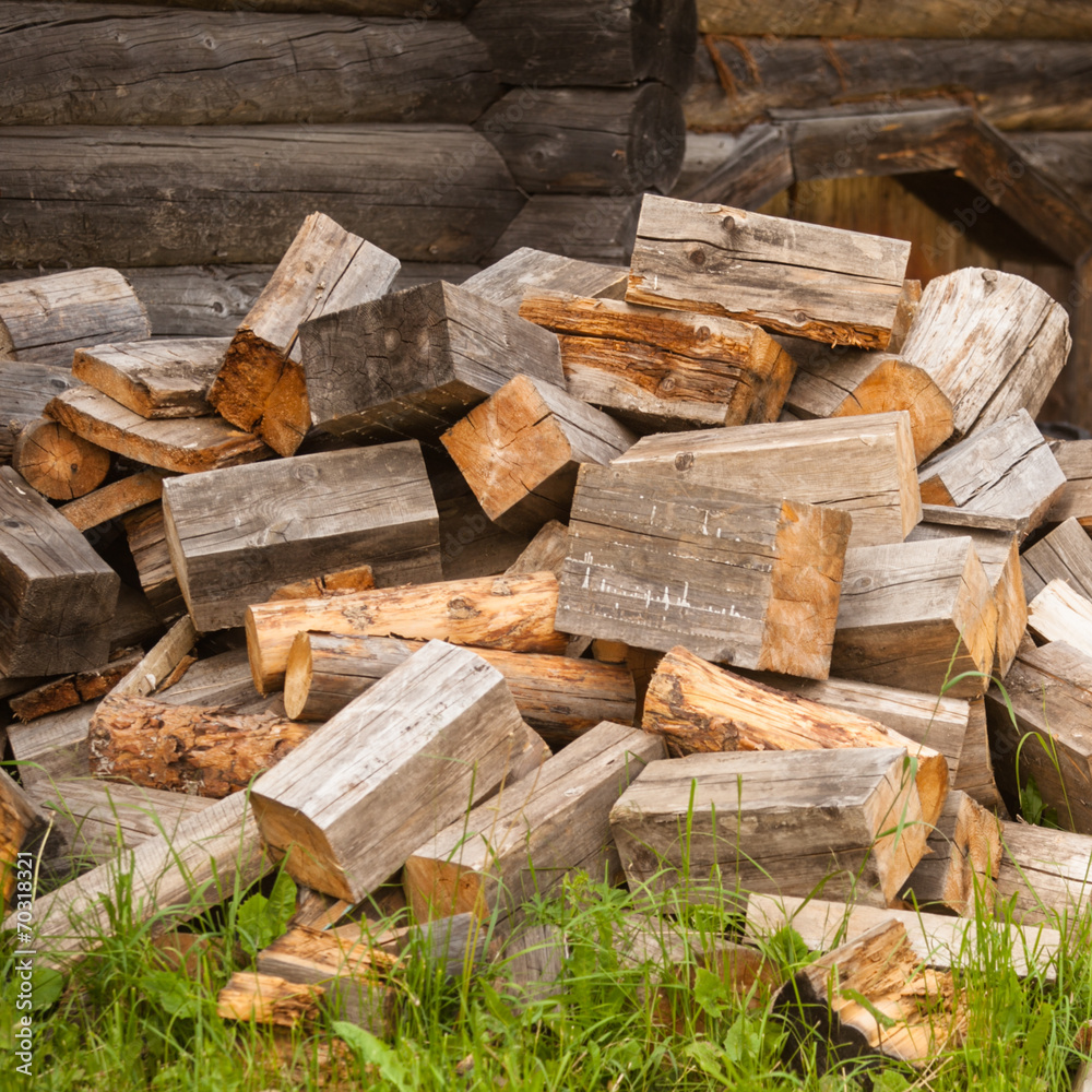 chaotic pile of firewood logs lying on green grass chaotic pile of firewood logs lying on green grass