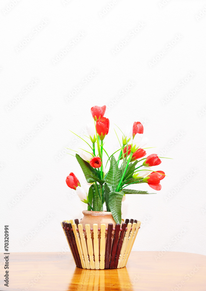 Red and White Rose in the mud Vase over Wood table against the W