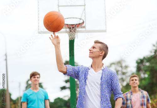 group of smiling teenagers playing basketball © Syda Productions