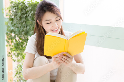 部屋で本を読む女性
