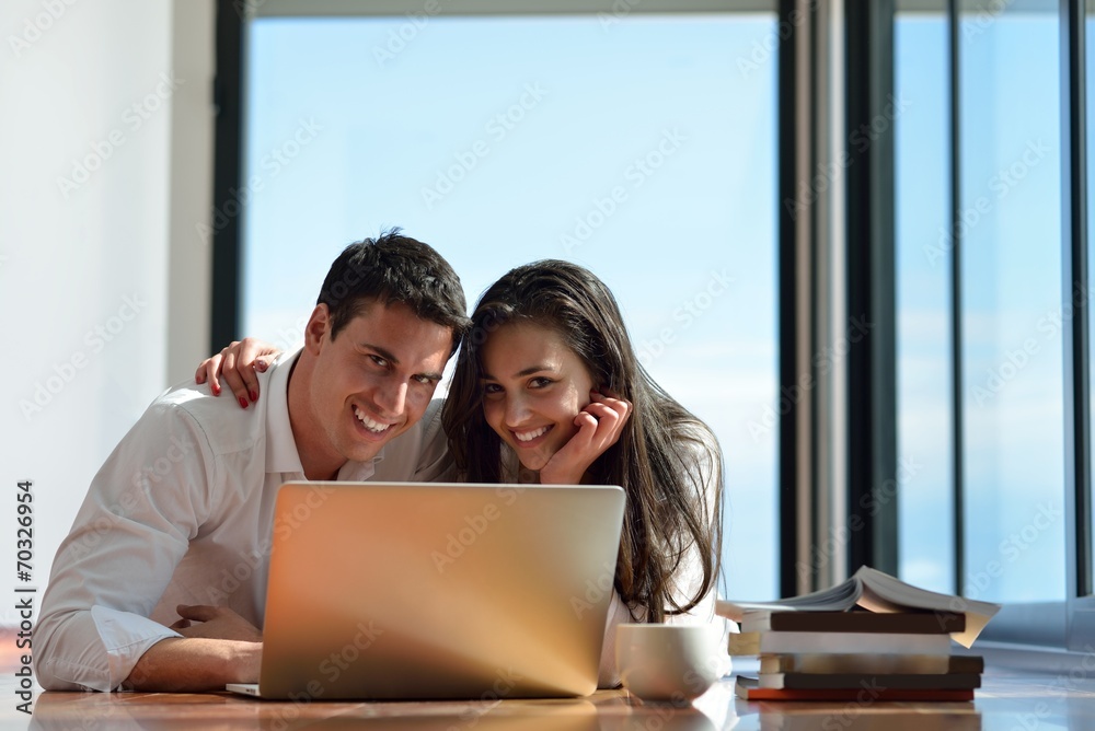 relaxed young couple working on laptop computer at home relaxed young couple working on laptop computer at home