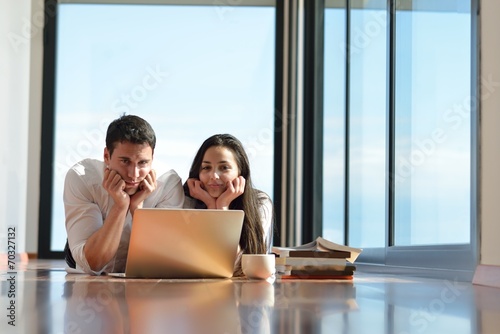 relaxed young couple working on laptop computer at home