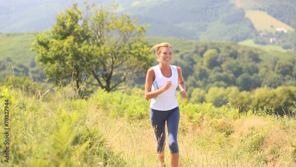 Athletic woman running in countryside 