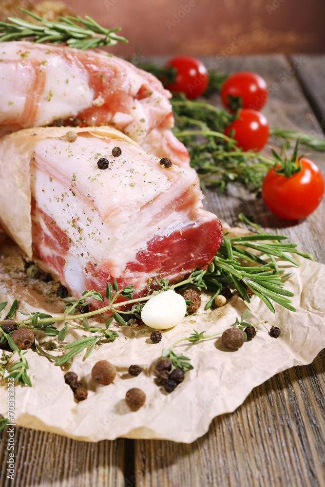 raw bacon with spices and tomatoes on wooden table raw bacon with spices and tomatoes on wooden table