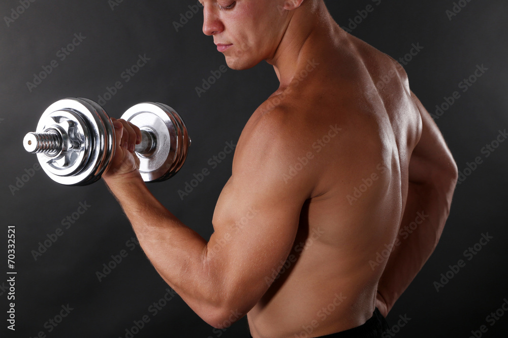 Handsome young muscular sportsman execute exercise with