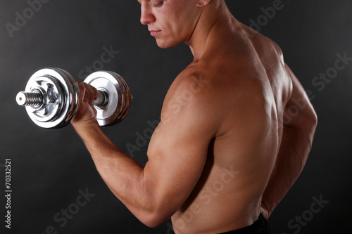 Handsome young muscular sportsman execute exercise with