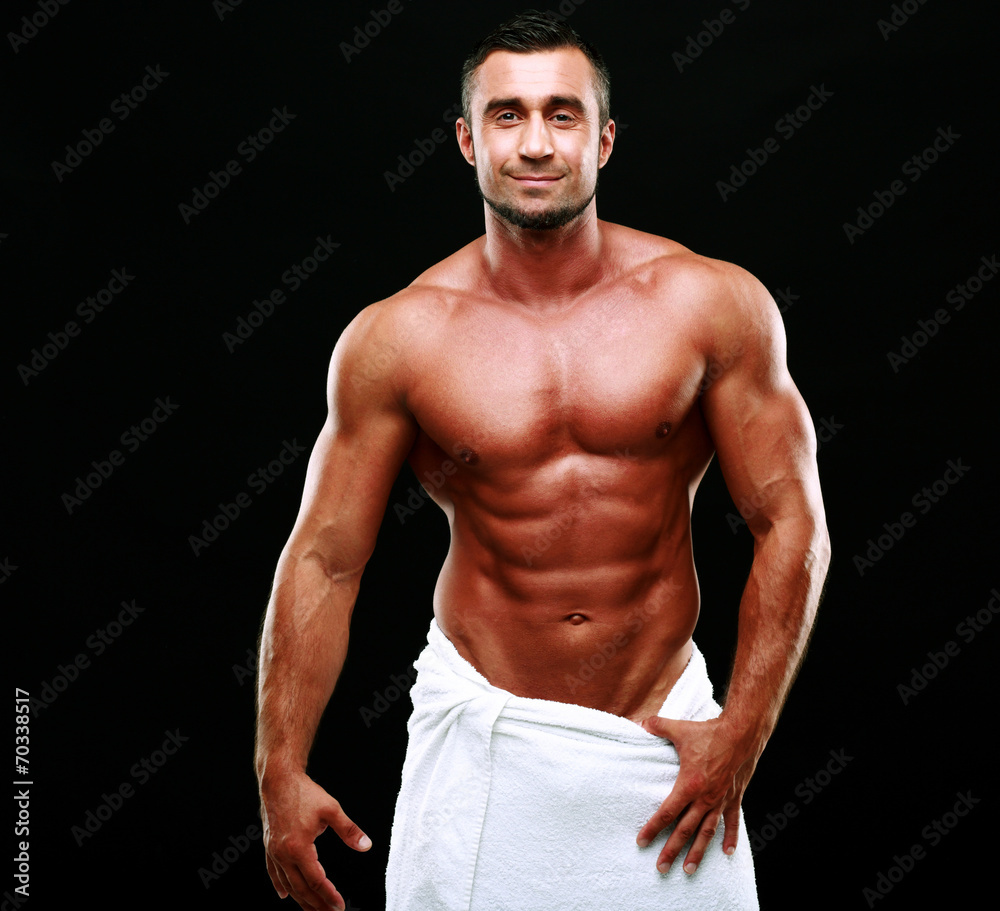 Portrait of a happy muscular man over black background