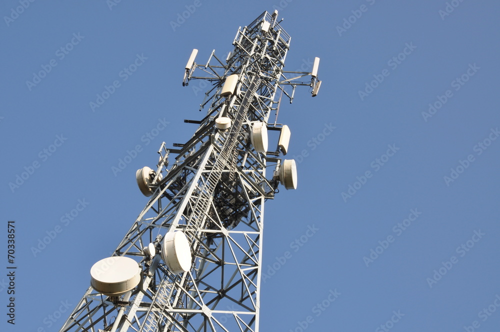 Telecommunication tower with antennas against the blue sky