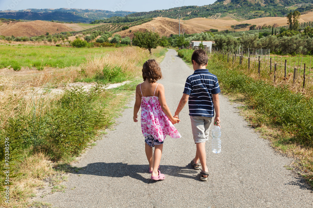 two children walking outdoor in the nature on the road two children walking outdoor in the nature on the road