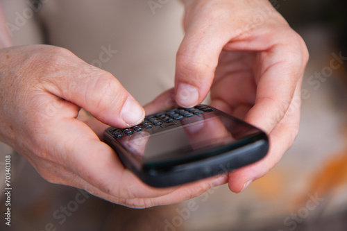 Młoda kobieta używa telefonu komórkowego i laptopa do komunikacj