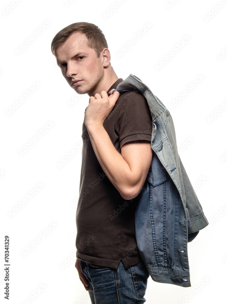 Portrait of a confident young man with jeans jacket on a white b Portrait of a confident young man with jeans jacket on a white b