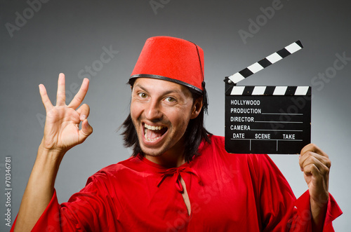 Man wearing fez hat with movie board photo