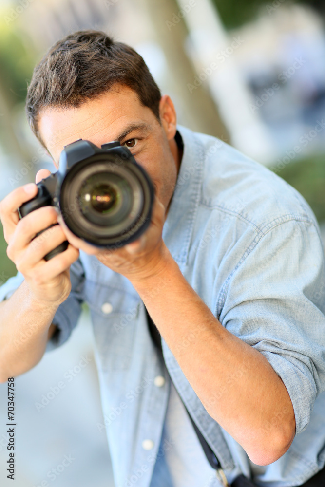 Photographer using reflex camera outside Photographer using reflex camera outside