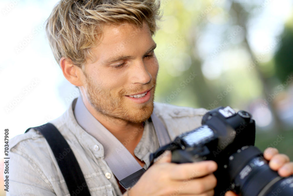 Photographer checking shots on camera screen Photographer checking shots on camera screen