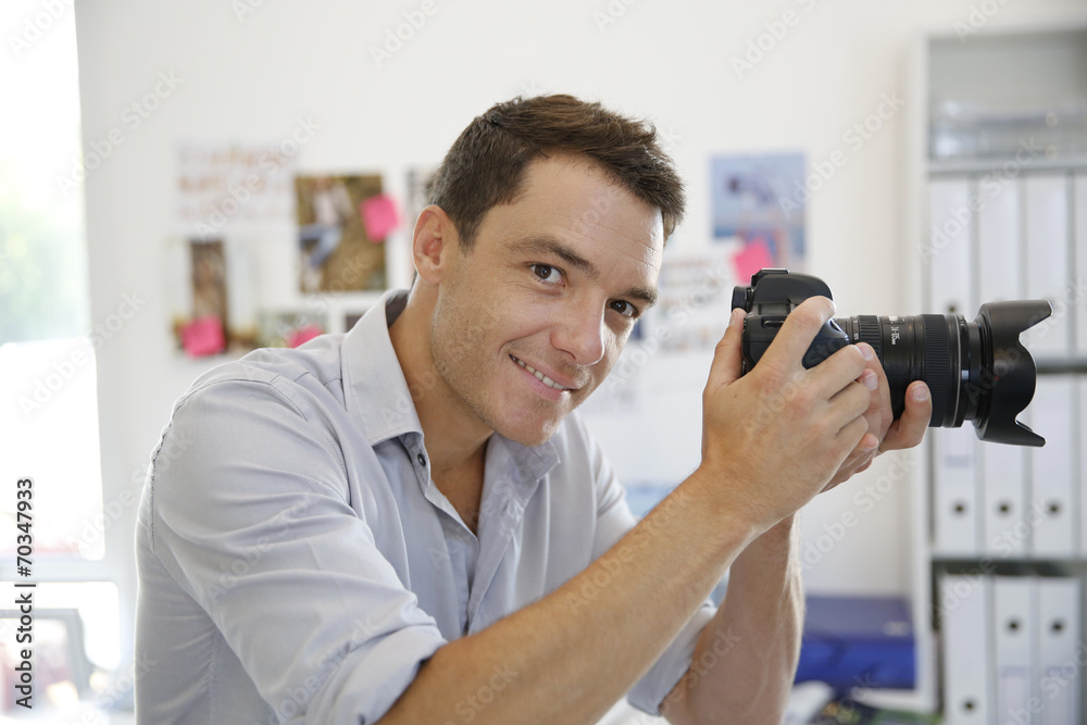 Portrait of photographer taking pictures in studio