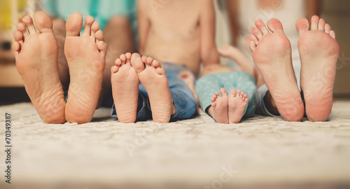 Family lying in bed together-focus on your feet. photo