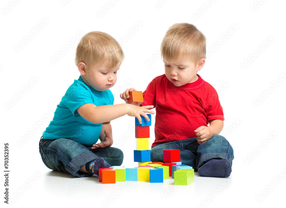 Two kids playing wooden blocks together building tower Two kids playing wooden blocks together building tower