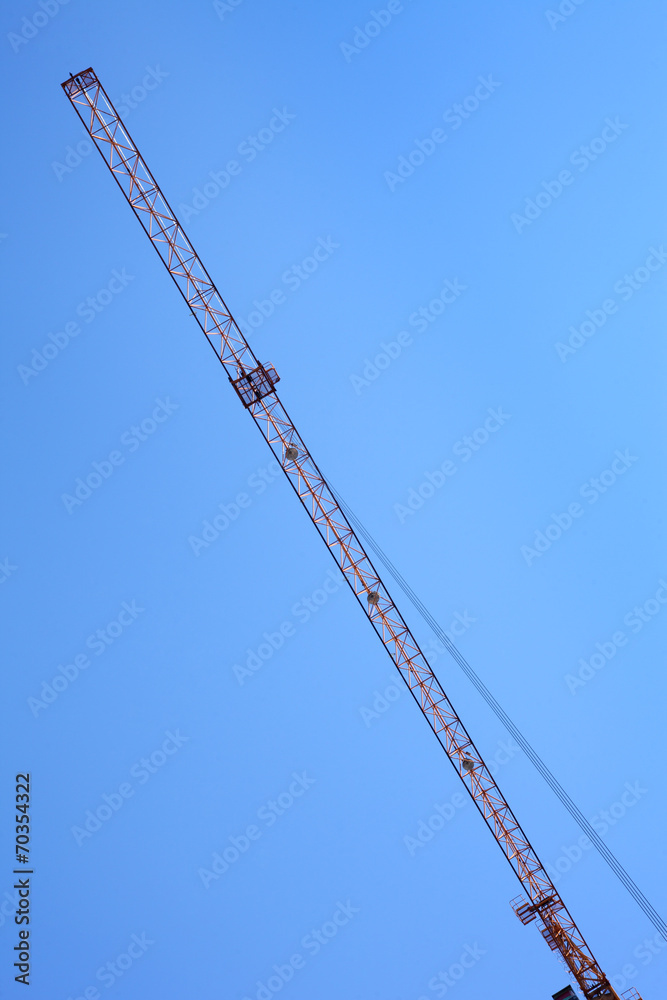 Modern tower crane against blue sky. Arrow of the tower crane. Modern tower crane against blue sky. Arrow of the tower crane.