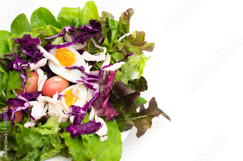 Fresh salad with boiled egg in a white plate