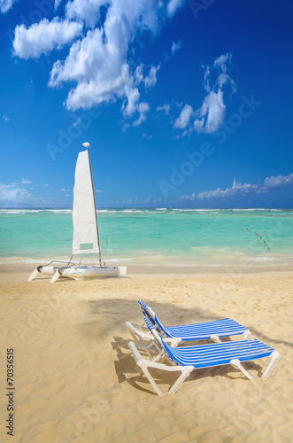 Fototapeta Naklejka Na Ścianę i Meble -  White catamaran and sunbeds on one of the sandy Caribbean beach