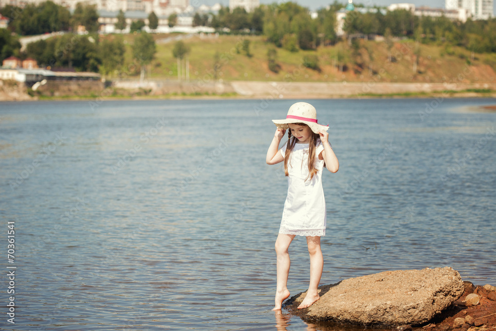 Curious little girl walking along river bank