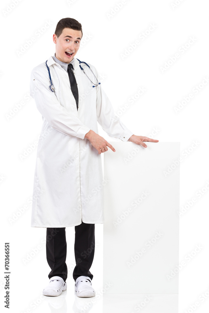 Shocked male doctor pointing at blank placard Shocked male doctor pointing at blank placard