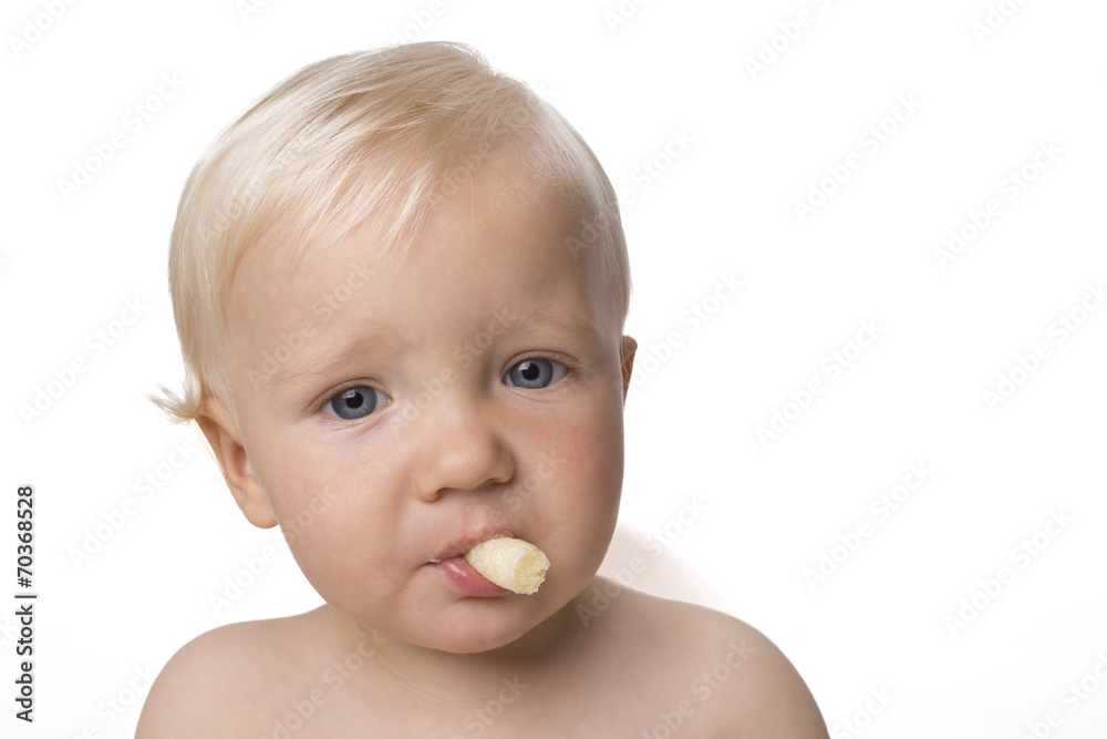 One year old boy eating himself corn snack One year old boy eating himself corn snack
