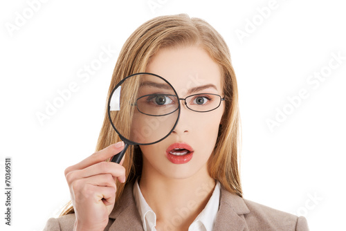 Businesswoman looking into a magnifying glass