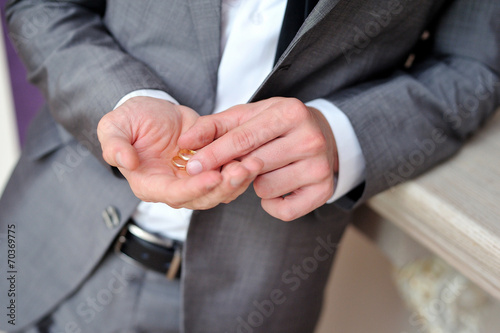 groom holding a gold rings © lisovoy