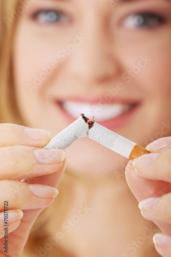 Young beautiful woman holding broken cigarette