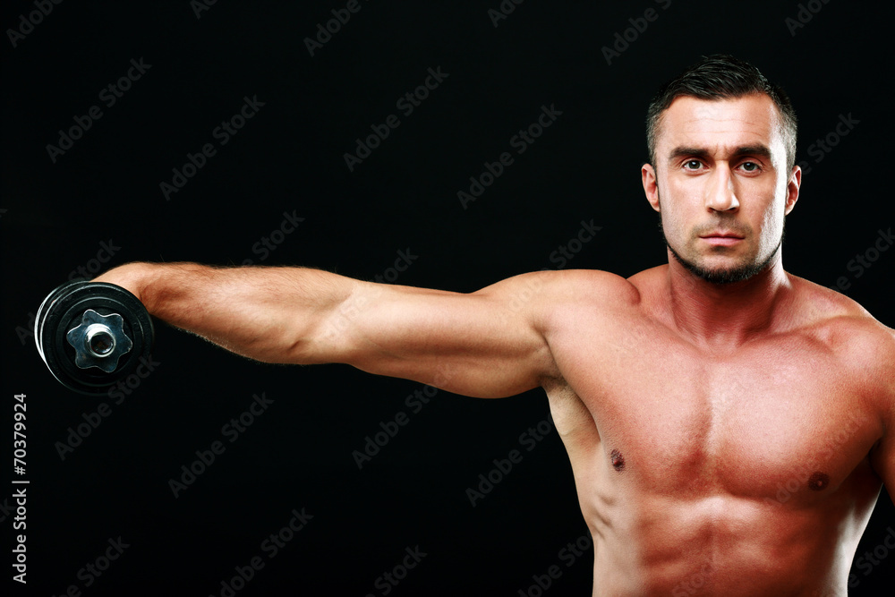 Portrait of a sportsman lifting dumbbell over black background Portrait of a sportsman lifting dumbbell over black background