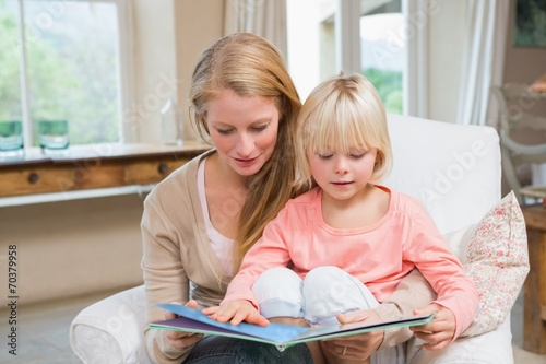 Happy mother and daughter reading together