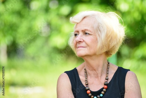 Obraz na płótnie Mature, blonde woman in garden, w salonie