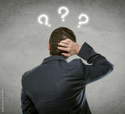 Businessman thinking of problem solution with quest marks over