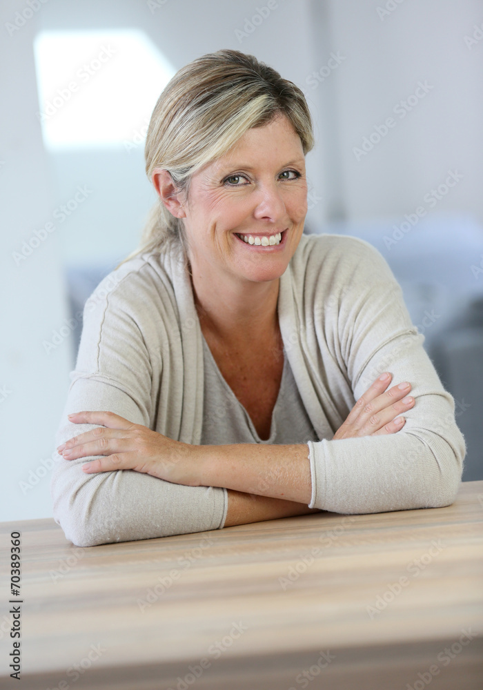 Portrait of smiling confident woman sitting at table Portrait of smiling confident woman sitting at table