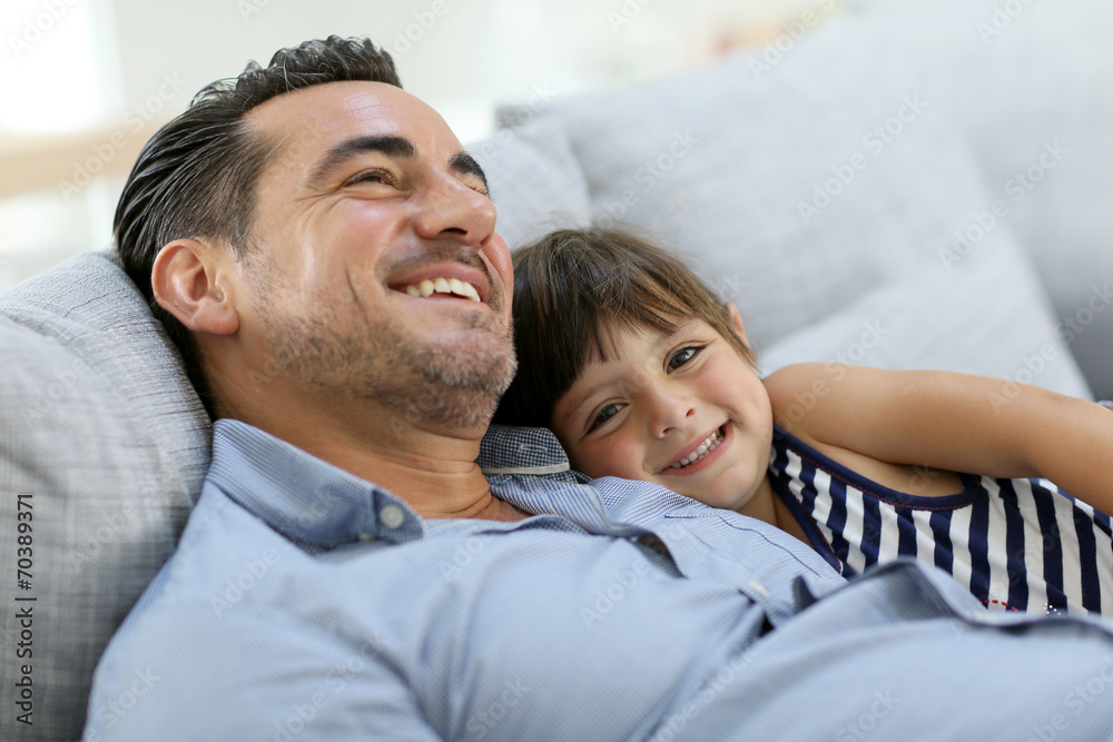 Daddy with little girl relaxing in sofa