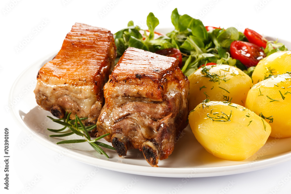 Tasty grilled ribs with vegetables on white background