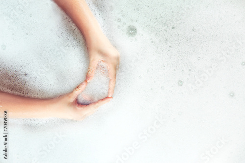 Child hands in a heart shape in soap foam. Medical concept.