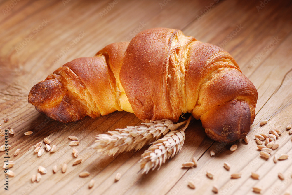 brioche con spighe di grano sul tavolo di legno brioche con spighe di grano sul tavolo di legno
