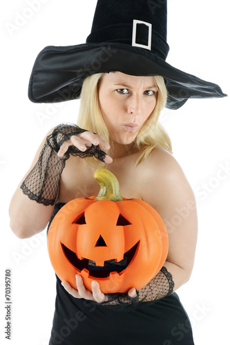 Hexe zu Halloween hält Kürbis