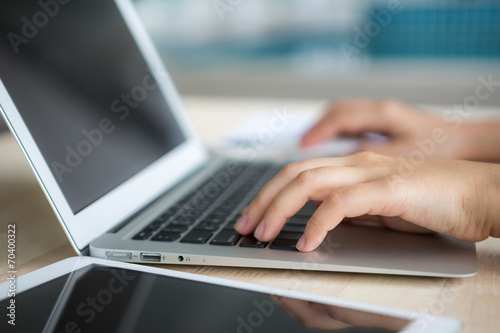 Closeup of business woman hand typing on laptop keyboard