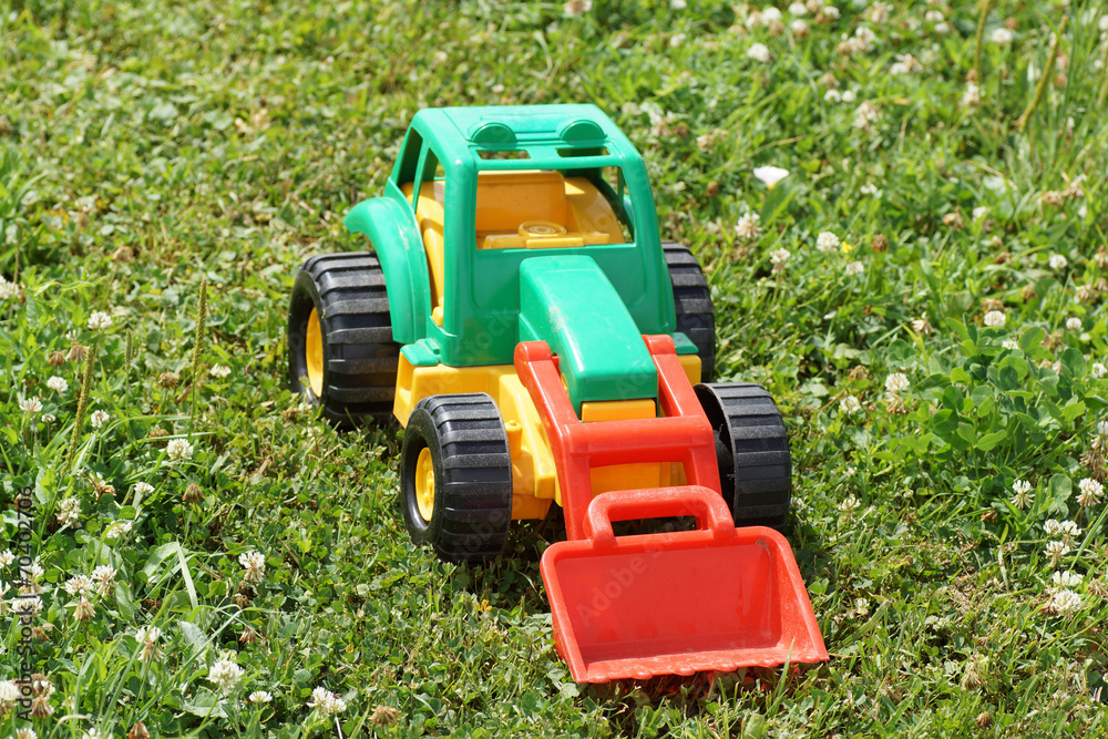 Obraz premium Toy green tractor on the grass.