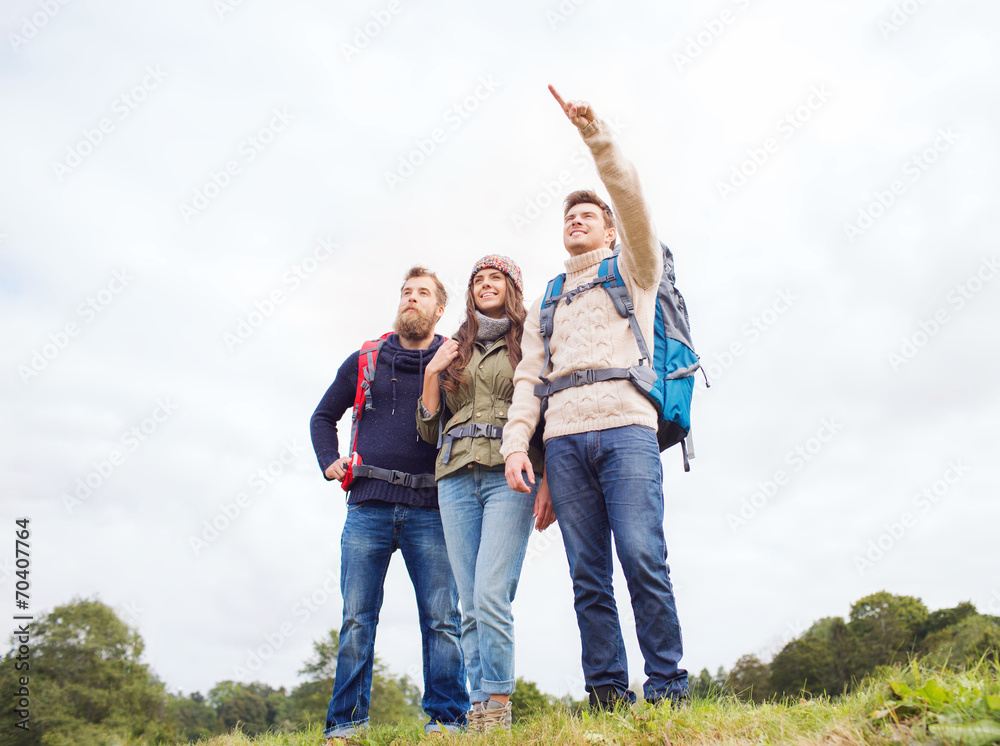 Fototapeta premium group of smiling friends with backpacks hiking