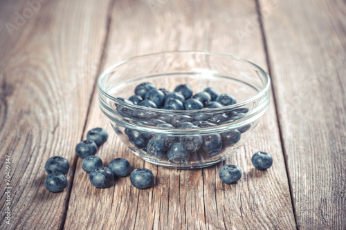 Fresh blueberries in bowl on wooden table 