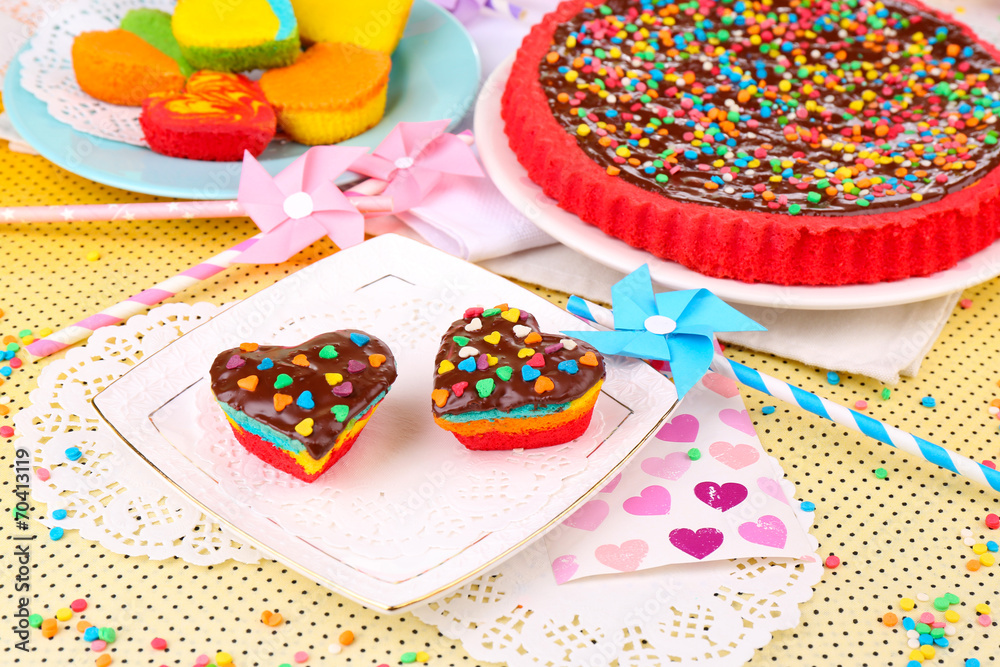 Delicious rainbow cakes on plates, on bright background Delicious rainbow cakes on plates, on bright background