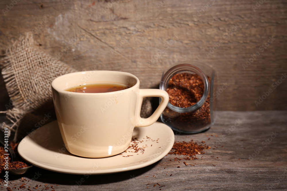 Fototapeta premium Cup of tasty rooibos tea, on wooden table