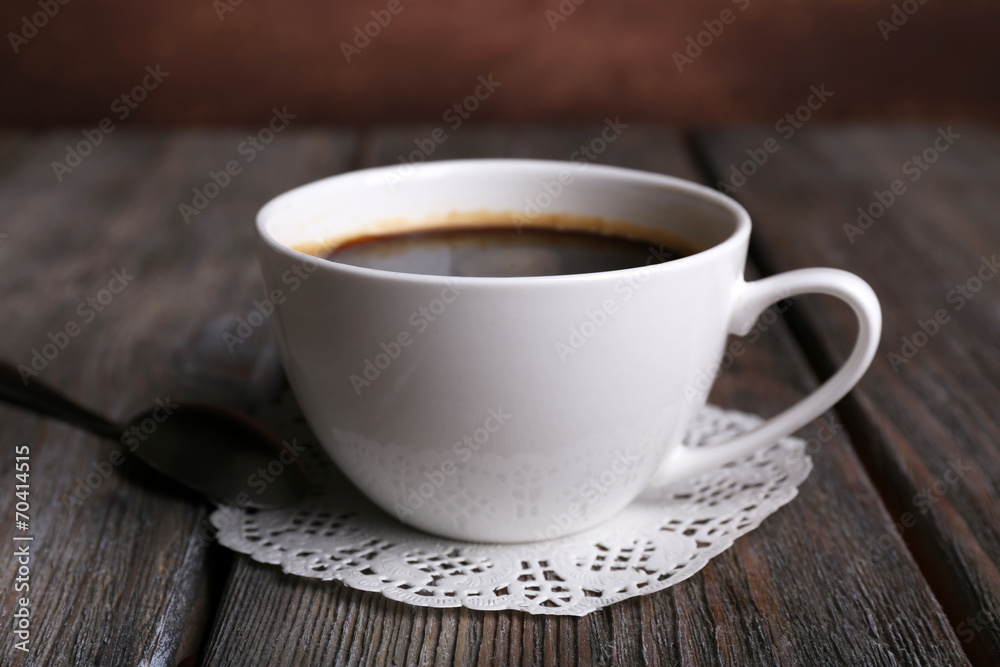 Cup of coffee on napkin on wooden background Cup of coffee on napkin on wooden background